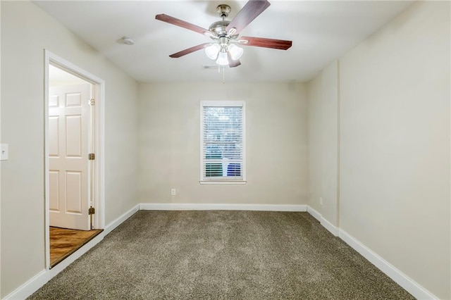 carpeted spare room with ceiling fan and baseboards