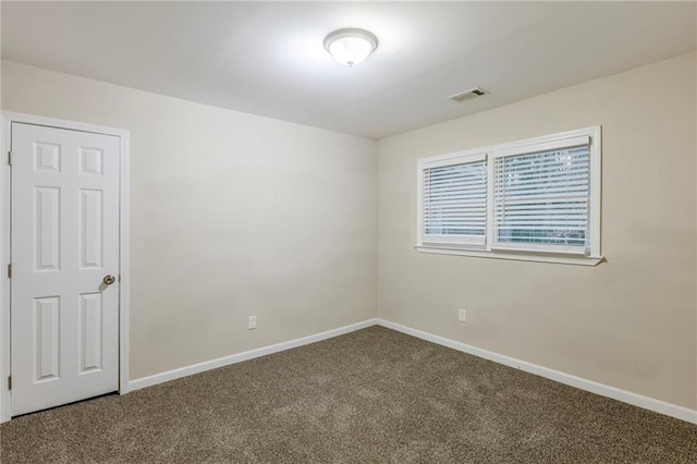 empty room with baseboards, visible vents, and carpet flooring