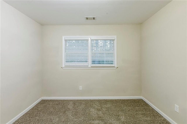 unfurnished room featuring baseboards, visible vents, and carpet flooring