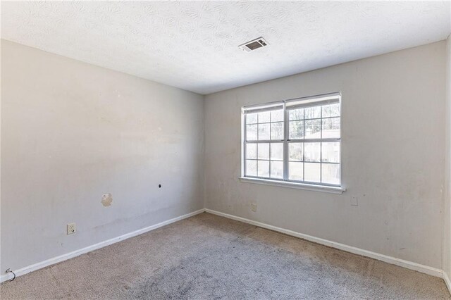 unfurnished room featuring carpet, visible vents, and baseboards