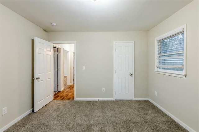 unfurnished bedroom featuring carpet floors and baseboards