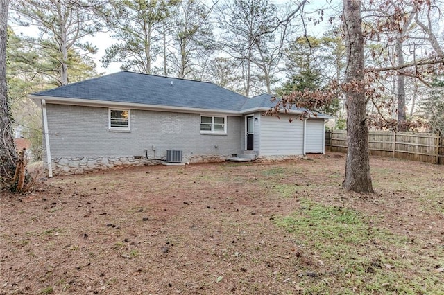 rear view of property with crawl space, fence, central AC, and brick siding