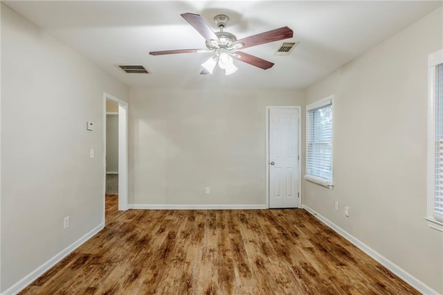 empty room with a ceiling fan, visible vents, and baseboards