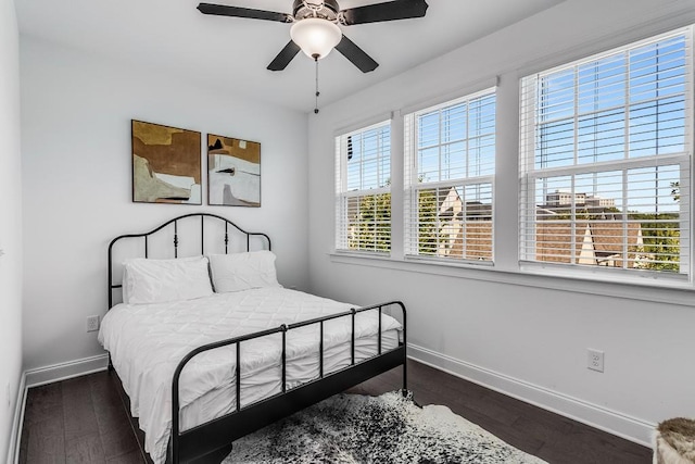 bedroom with ceiling fan, dark hardwood / wood-style floors, and multiple windows