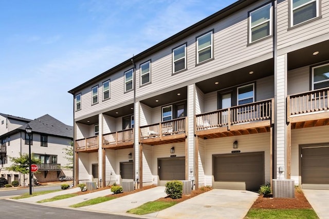 exterior space with a balcony, central AC unit, and a garage