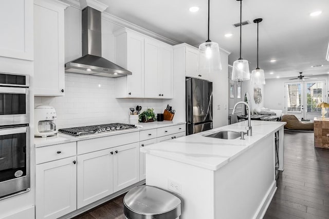 kitchen featuring sink, white cabinetry, wall chimney exhaust hood, stainless steel appliances, and ceiling fan