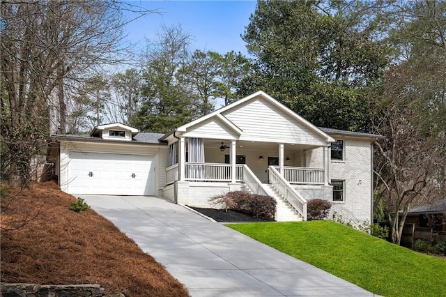 view of front facade featuring covered porch, ceiling fan, a garage, driveway, and a front lawn