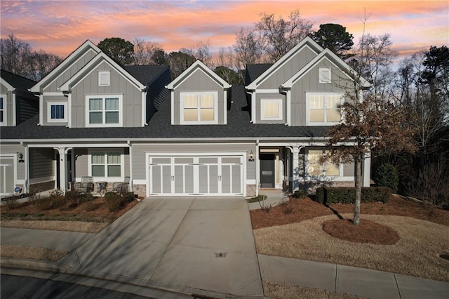 view of front of home featuring roof with shingles, covered porch, concrete driveway, a garage, and board and batten siding