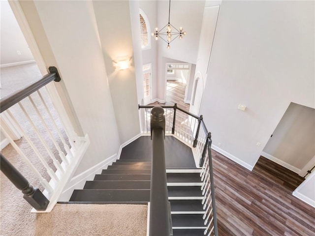 11405 Donnington Dr, Duluth, GA 30097 - stairs with a chandelier, wood finished floors, and a towering ceiling