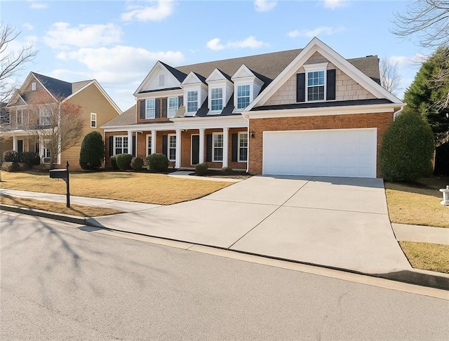 view of front facade featuring an attached garage, brick siding, a front yard, covered porch, and driveway