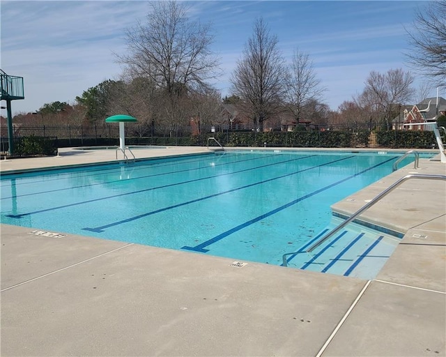 community pool featuring fence and a patio area