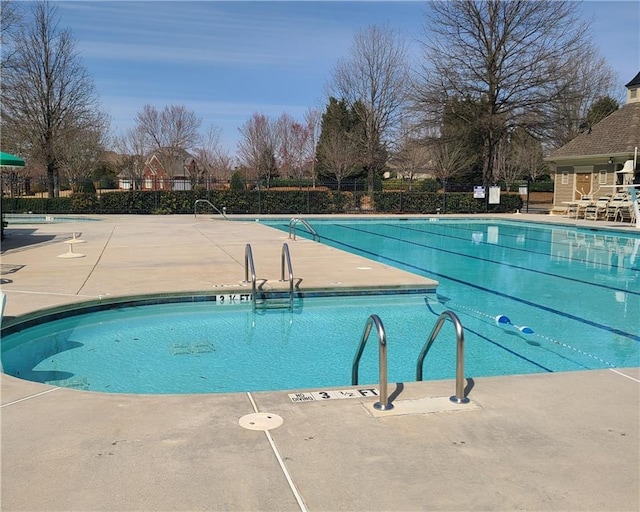community pool featuring fence and a patio