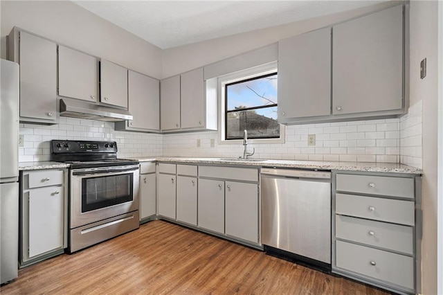 kitchen with gray cabinetry, light hardwood / wood-style flooring, stainless steel appliances, and sink