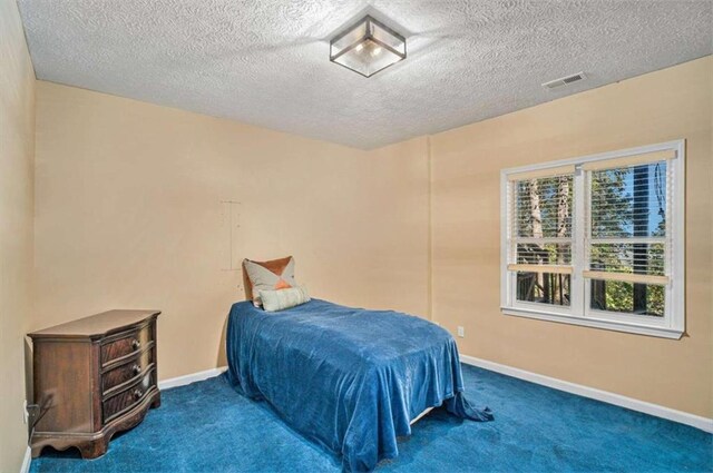 bathroom with a textured ceiling, tile patterned floors, and a tub to relax in