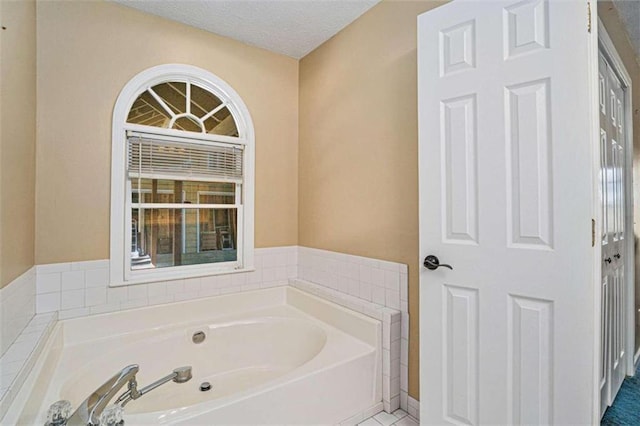 bathroom with tile patterned flooring, a textured ceiling, and a bathtub