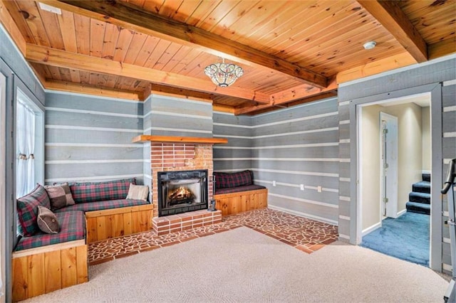 carpeted living room featuring a fireplace, wooden ceiling, and beamed ceiling