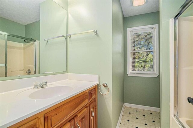 bathroom featuring shower / bath combination with glass door and vanity