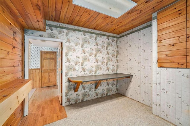 interior space featuring wood walls and light carpet