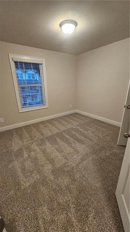 spare room featuring dark carpet