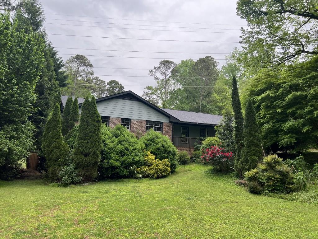 7235 Thornhill Ln NE, Atlanta, GA 30328 - view of front facade with a front lawn and brick siding