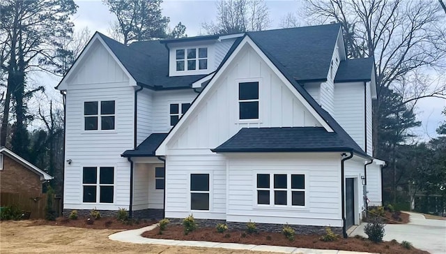 modern inspired farmhouse featuring board and batten siding and roof with shingles