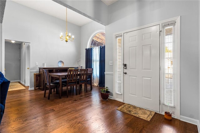 foyer with dark hardwood / wood-style flooring and a chandelier