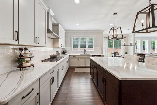 107 Equest Dr, Canton, GA 30115 - kitchen with stainless steel gas stovetop, wall chimney range hood, ornamental molding, a spacious island, and a chandelier