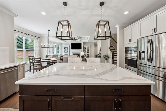 107 Equest Dr, Canton, GA 30115 - kitchen featuring stainless steel appliances, a chandelier, white cabinetry, dark brown cabinetry, and ornamental molding