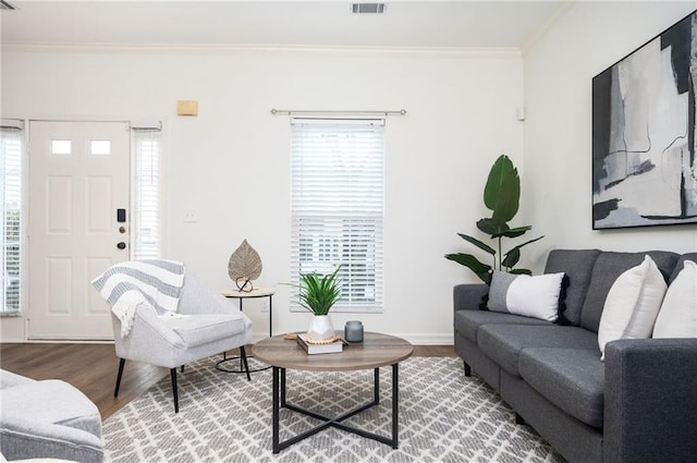 living room featuring ornamental molding, plenty of natural light, and wood finished floors