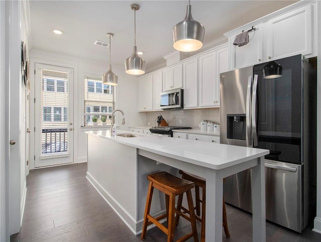 kitchen with white cabinets, pendant lighting, sink, stainless steel appliances, and dark hardwood / wood-style floors