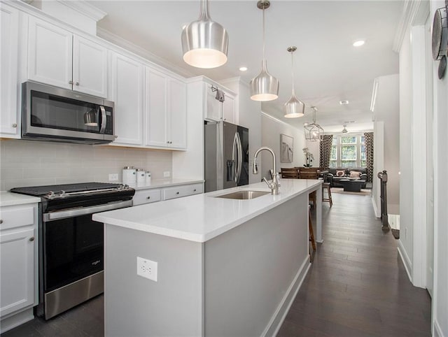 kitchen with an island with sink, dark hardwood / wood-style floors, white cabinetry, and stainless steel appliances