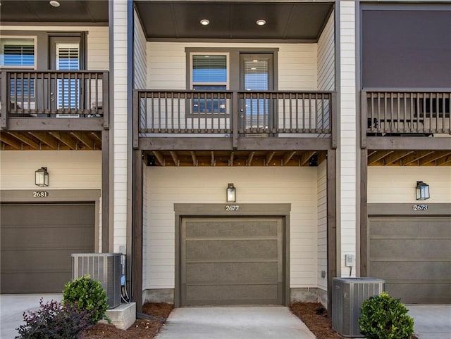 exterior space with central AC unit, a balcony, and a garage