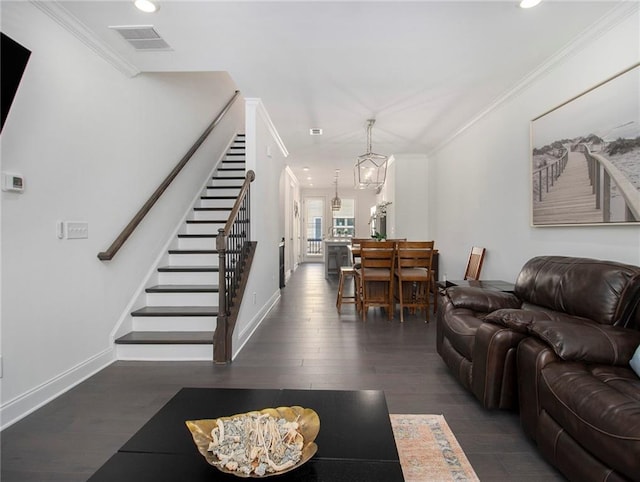 living room with a notable chandelier, crown molding, and dark hardwood / wood-style flooring