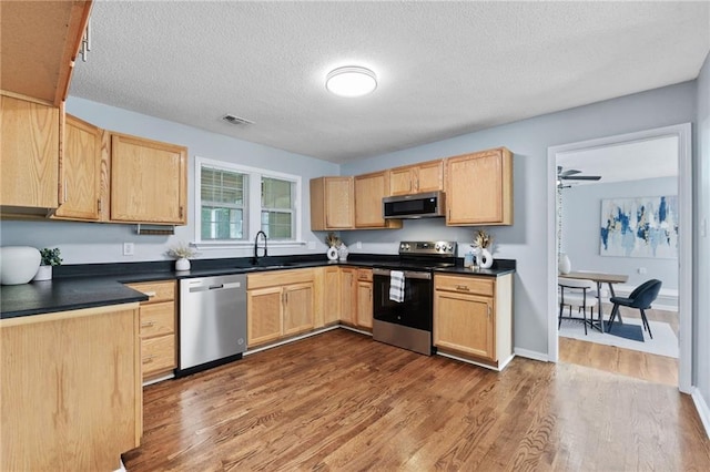 1694 Pheasant Dr, Atlanta, GA 30238 - kitchen featuring appliances with stainless steel finishes, light brown cabinets, dark countertops, and a textured ceiling