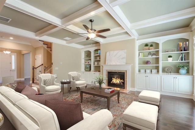 living room featuring beamed ceiling, coffered ceiling, dark wood-type flooring, and built in features