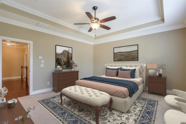 bedroom with ornamental molding, ceiling fan, and a tray ceiling