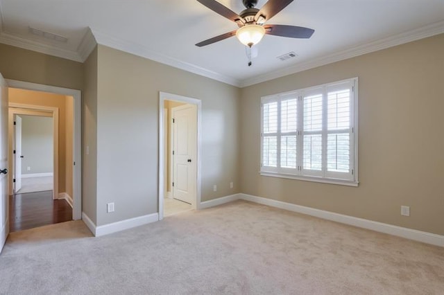 unfurnished bedroom featuring crown molding, light colored carpet, and ceiling fan