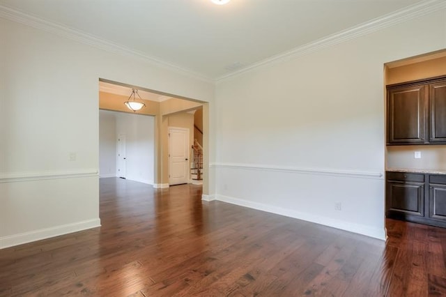 empty room with dark wood-type flooring and ornamental molding