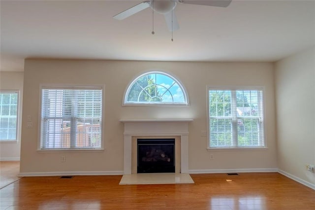 851 Roget Ct, Lawrenceville, GA 30045 - unfurnished living room featuring wood finished floors, a ceiling fan, and a glass covered fireplace