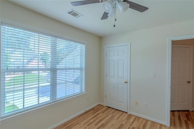 851 Roget Ct, Lawrenceville, GA 30045 - unfurnished bedroom with light wood-style floors, multiple windows, and a ceiling fan
