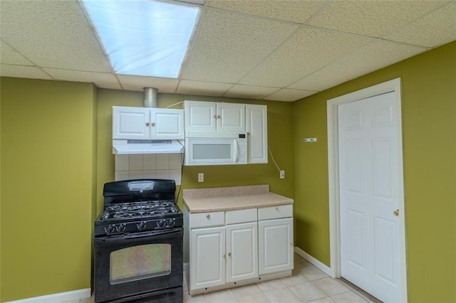 851 Roget Ct, Lawrenceville, GA 30045 - kitchen featuring black gas range, white microwave, under cabinet range hood, a paneled ceiling, and white cabinets