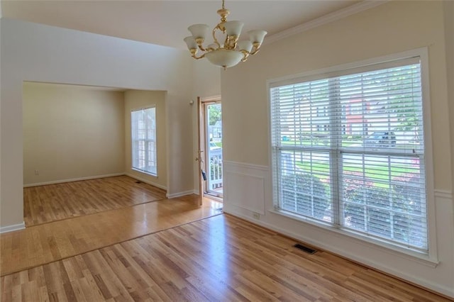 851 Roget Ct, Lawrenceville, GA 30045 - spare room with a chandelier, wood finished floors, healthy amount of natural light, and crown molding