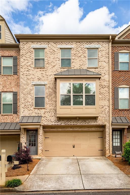 275 Blue Pointe Ct, Suwanee, GA 30024 - view of property with a garage, driveway, and brick siding