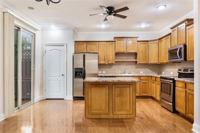 275 Blue Pointe Ct, Suwanee, GA 30024 - kitchen featuring appliances with stainless steel finishes, a sink, a center island, light wood-type flooring, and ceiling fan