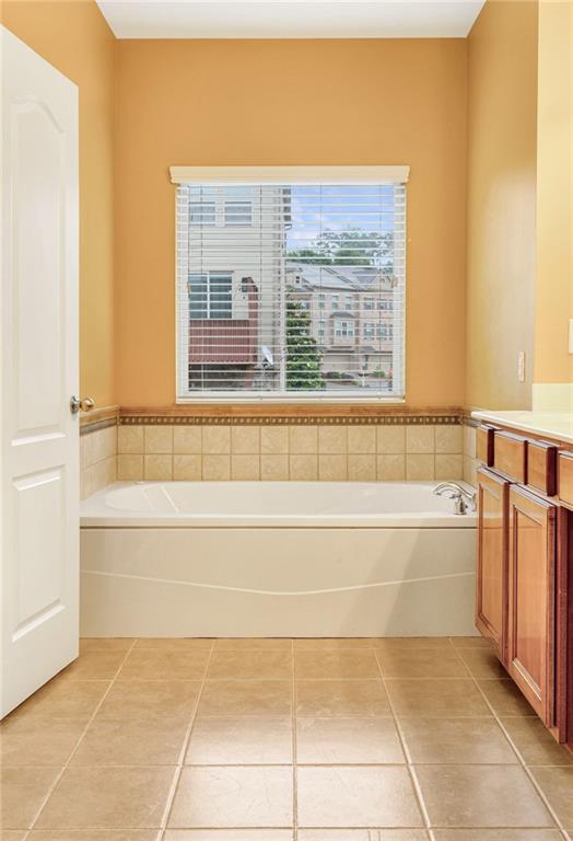 275 Blue Pointe Ct, Suwanee, GA 30024 - bathroom with double vanity, a shower stall, tile patterned floors, and baseboards