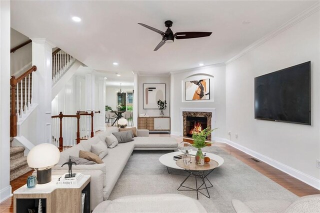 275 Blue Pointe Ct, Suwanee, GA 30024 - living area with crown molding, wood finished floors, a ceiling fan, stairs, and a premium fireplace