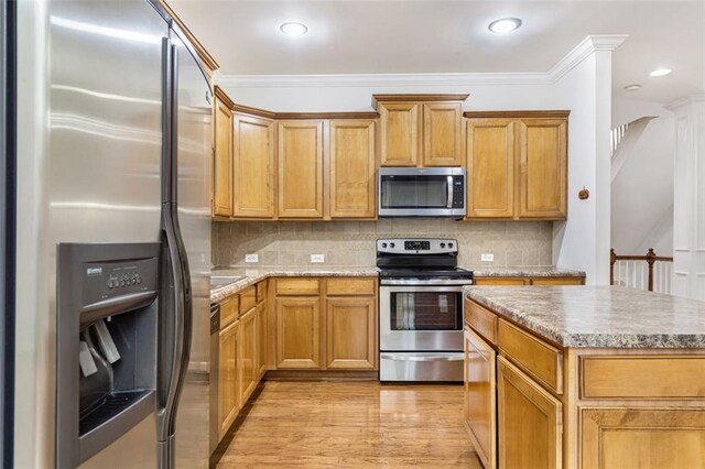 275 Blue Pointe Ct, Suwanee, GA 30024 - kitchen featuring stainless steel appliances, a center island, light wood-type flooring, backsplash, and crown molding