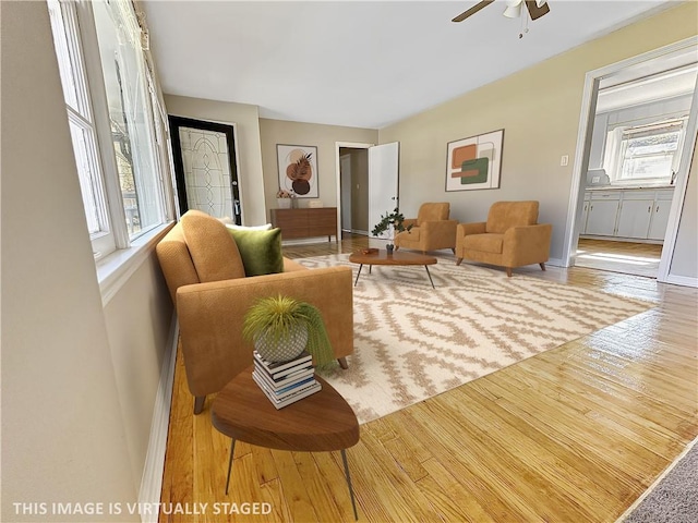 living room with ceiling fan, plenty of natural light, and hardwood / wood-style flooring