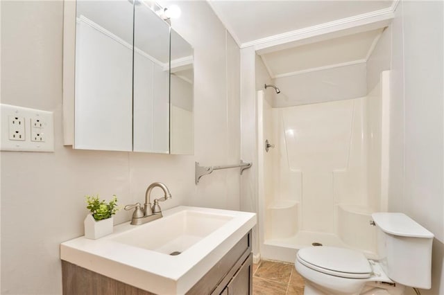 bathroom with tile patterned floors, walk in shower, vanity, crown molding, and toilet