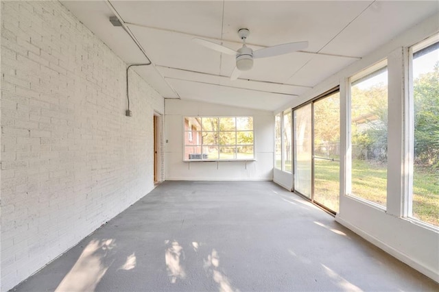 unfurnished sunroom featuring ceiling fan, a healthy amount of sunlight, and vaulted ceiling